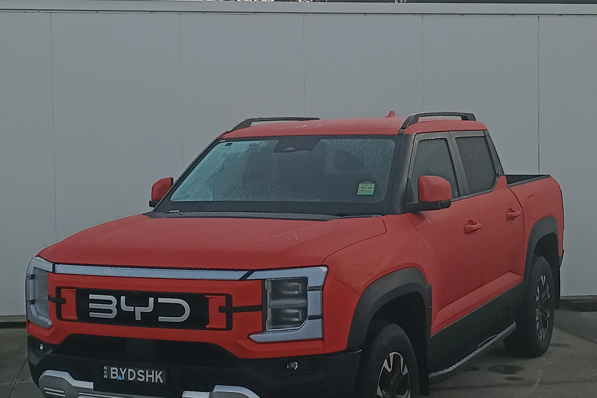 Outback Orange BYD Shark 6 pick-up parked at a dealership in West Gosford, NSW, front three-quarter view