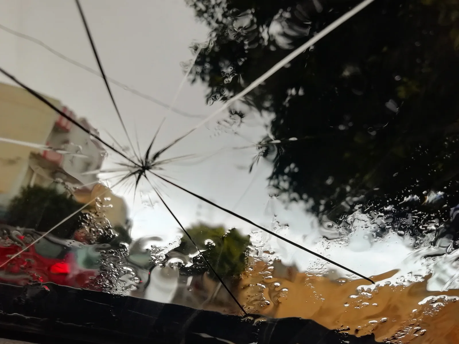 Windscreen with an impact point and long cracks radiating across the glass, too damaged to repair