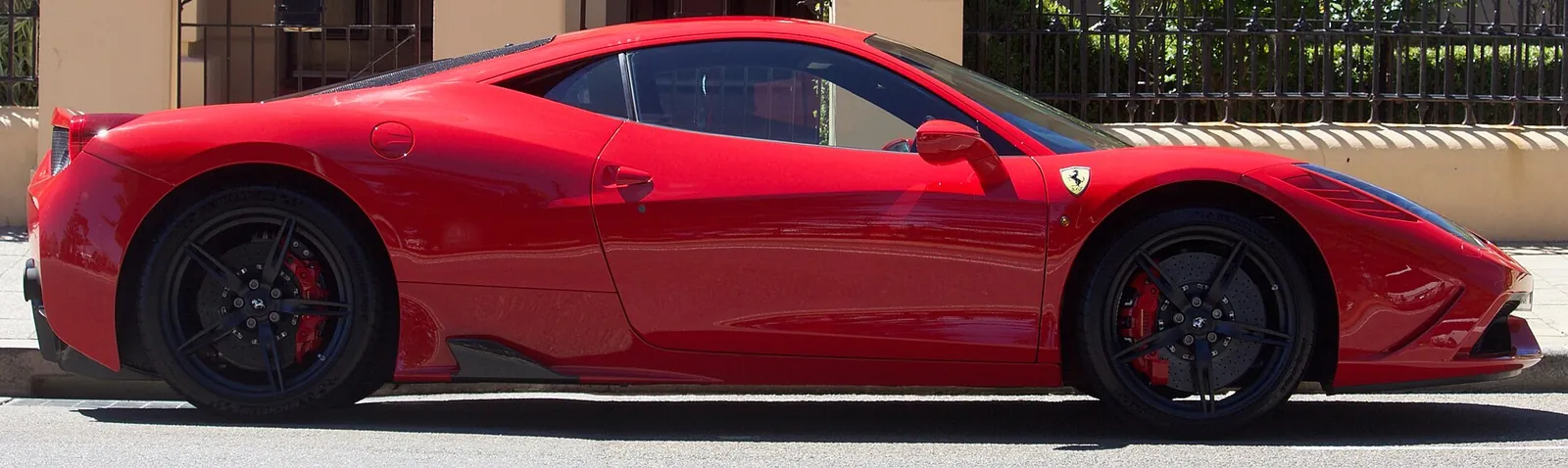 Full side profile of a red Ferrari 458 Speciale coupe parked on a street in Fremantle, Western Australia