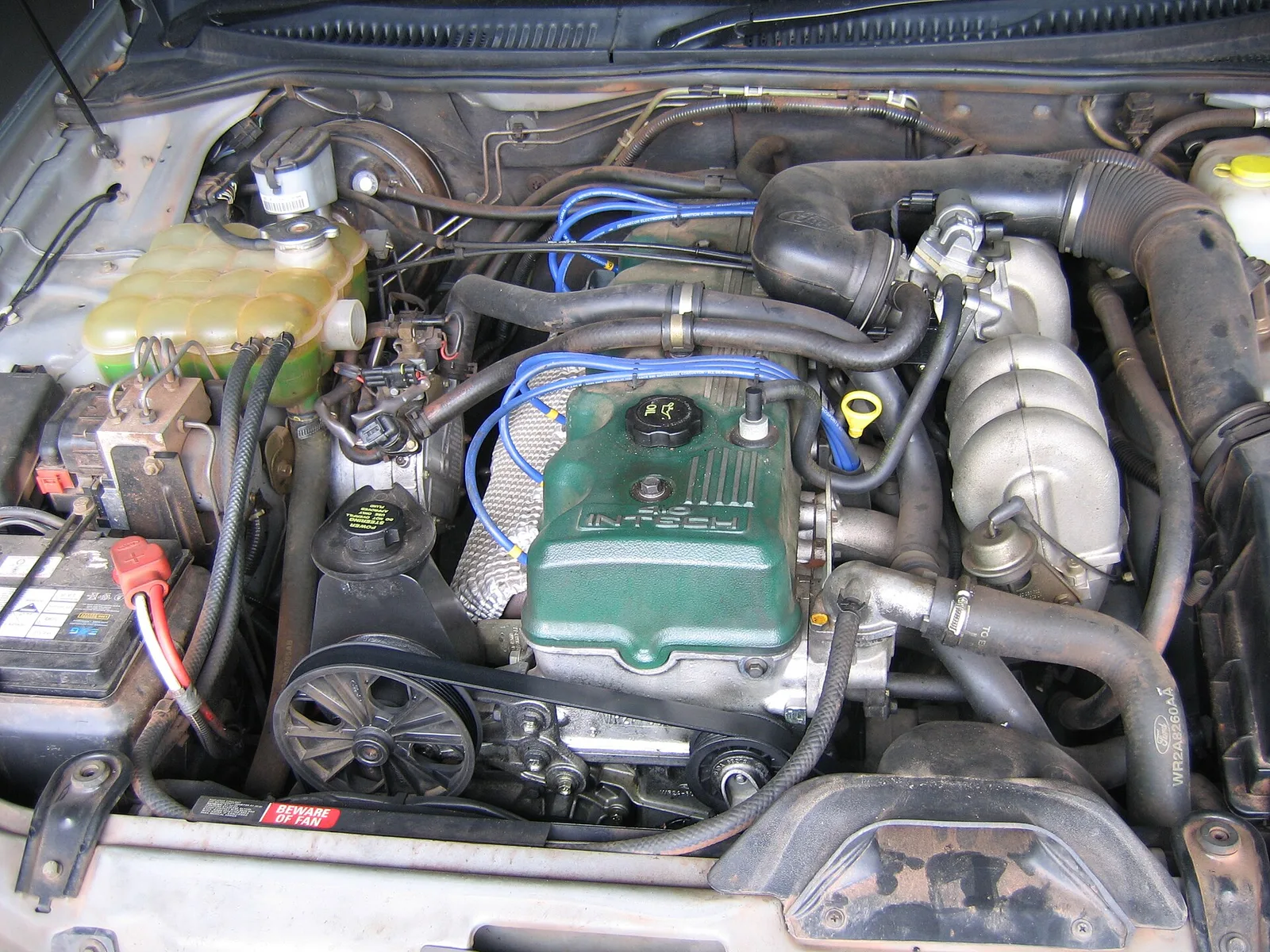 Bonnet up on a Ford AU Falcon showing the engine bay, a typical pre-purchase inspection view