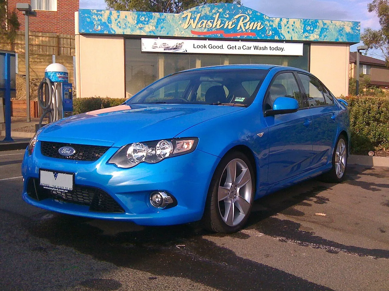 Blue 2009 Ford FG Falcon XR6 Turbo sedan on 19-inch alloy wheels parked outside a car wash