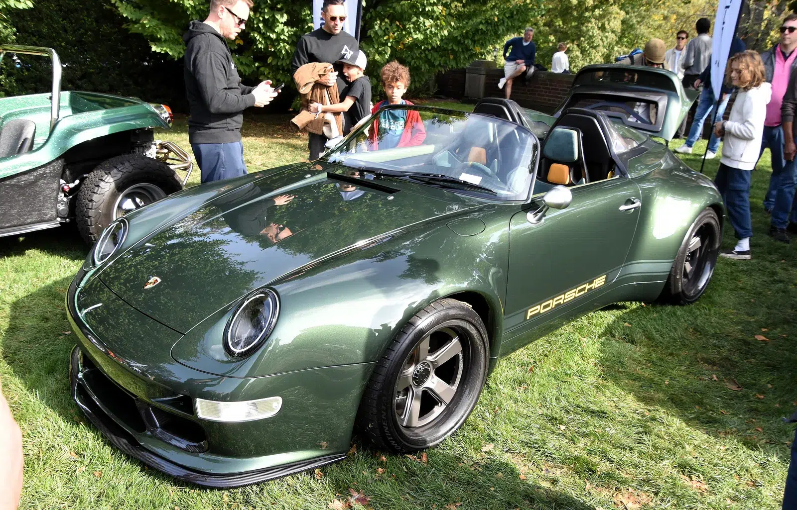 Green Gunther Werks 993 Speedster Launch Edition parked on grass, front three-quarter view showing the wide bodywork