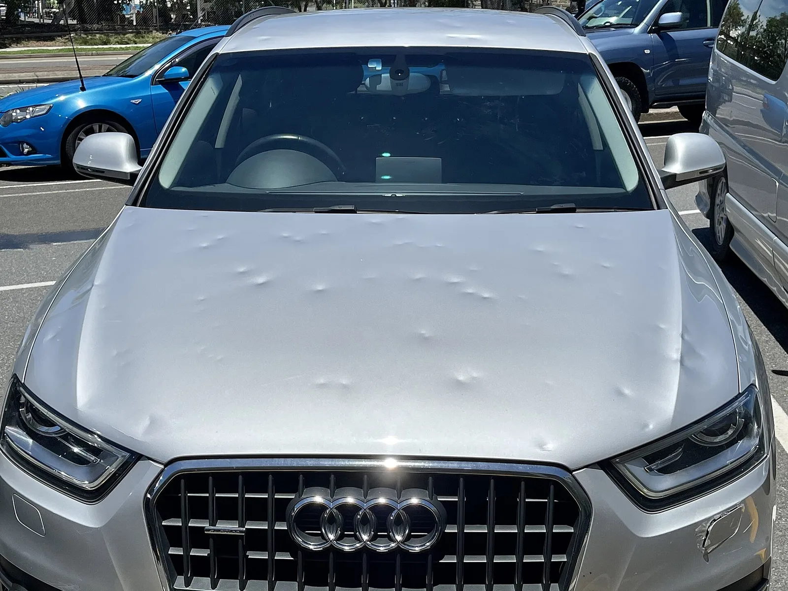 Silver Audi SUV with dozens of hail dents across its bonnet after a 2020 Brisbane hailstorm