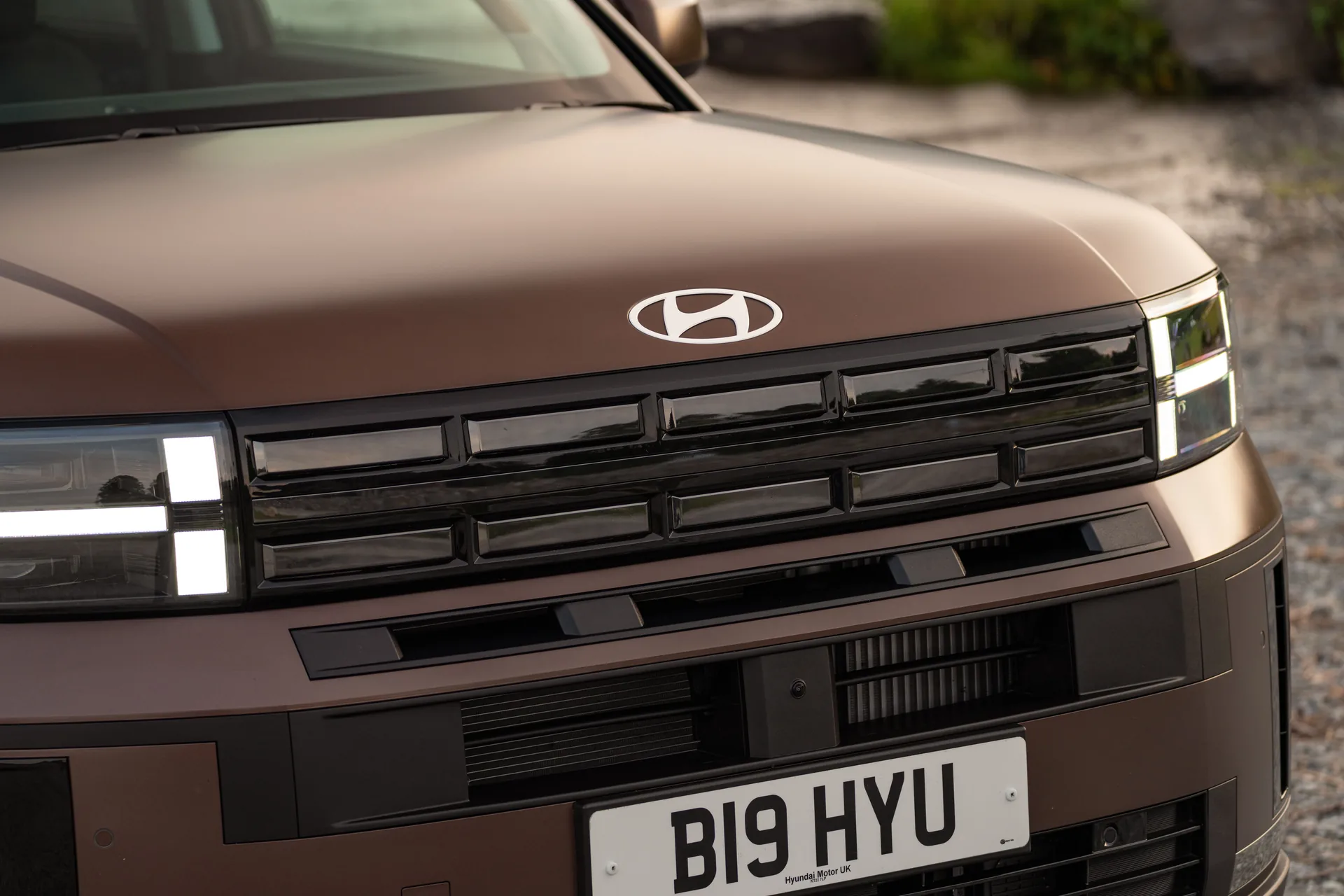 Close-up of the Hyundai Santa Fe front end showing its H-shaped LED daytime running lights and grille