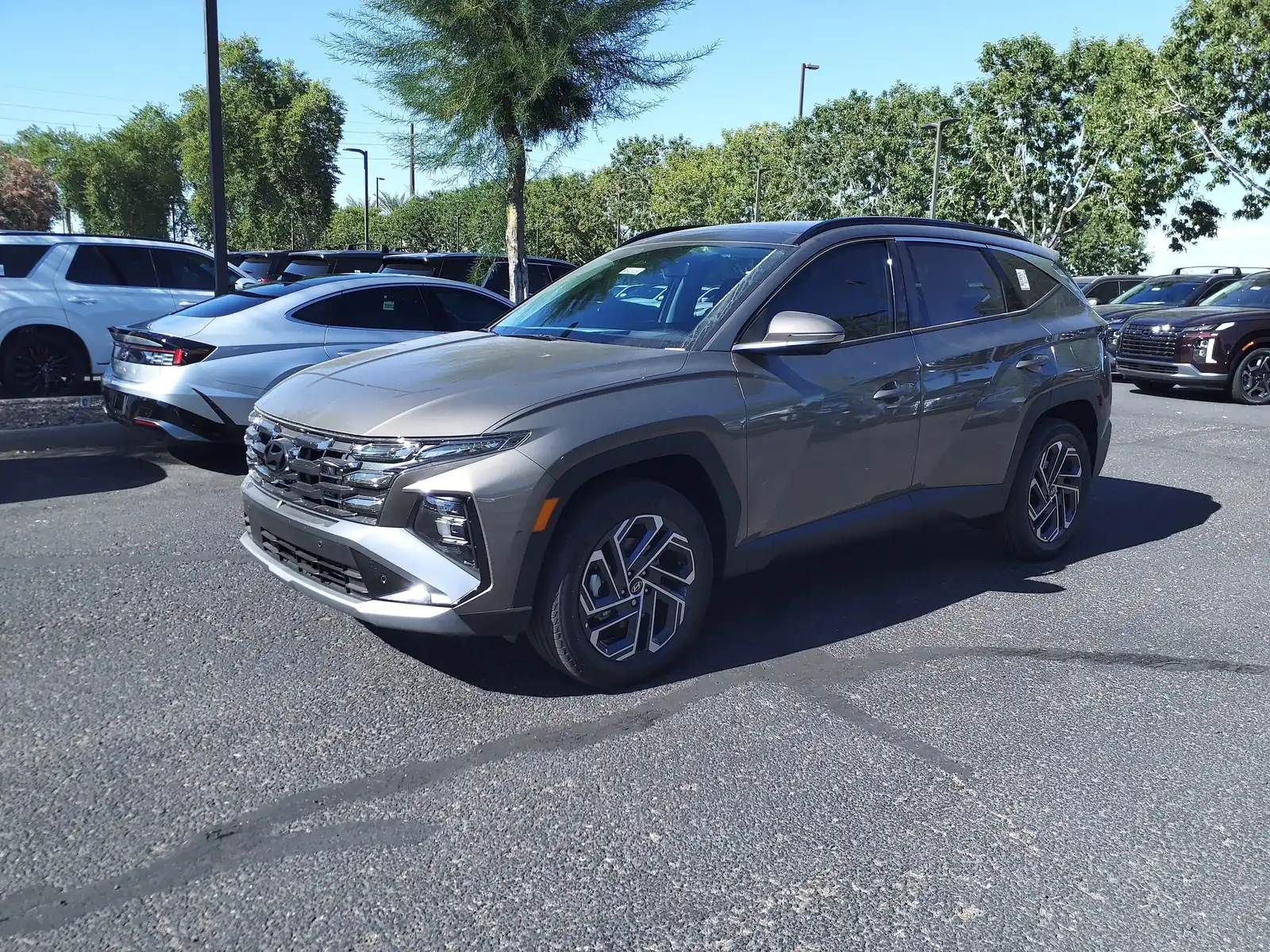 Grey facelifted Hyundai Tucson Hybrid at a dealership, a US-market car shown for styling