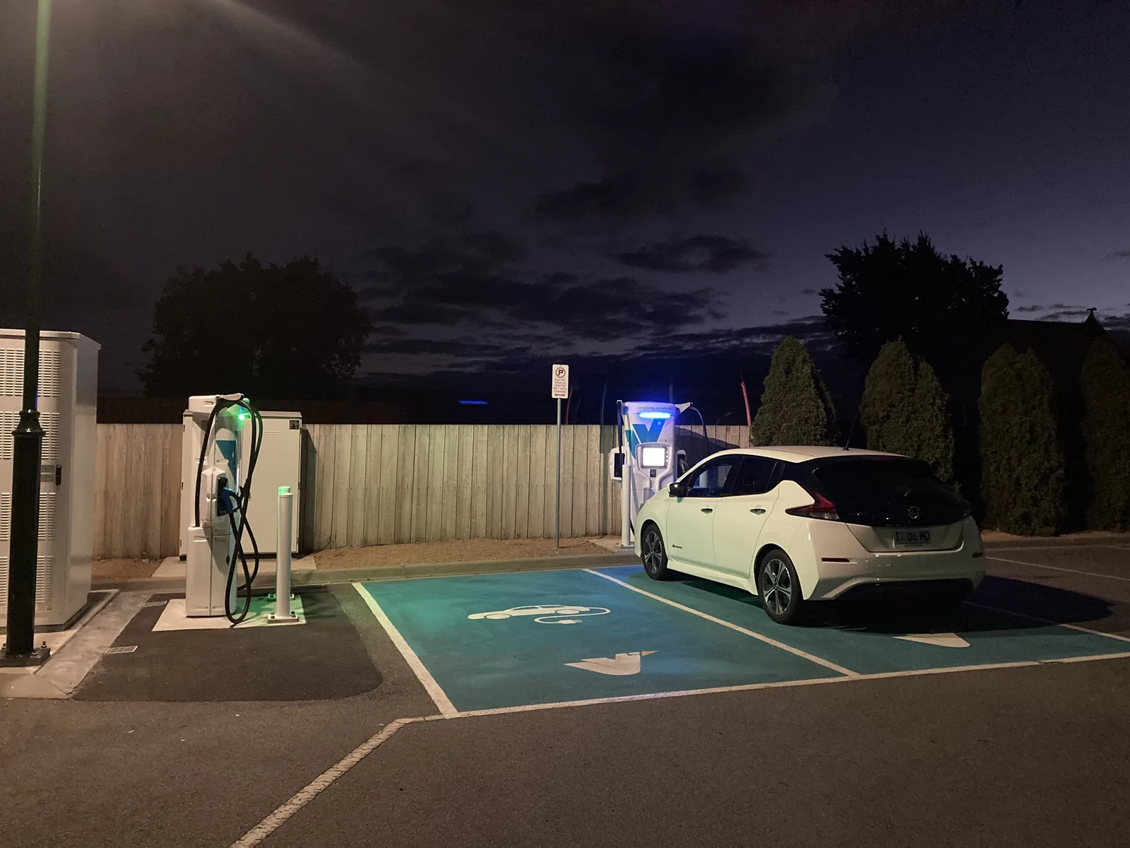 White Nissan Leaf charging at night at an Evie Networks station in Campbell Town, Tasmania, with green bay markings lit