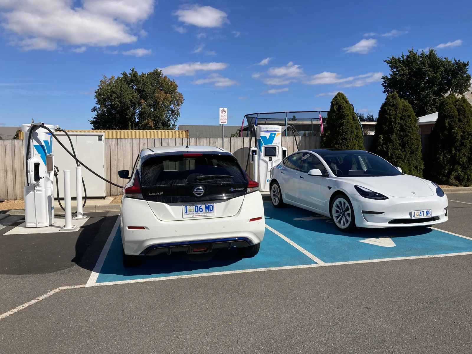 Nissan Leaf and Tesla Model 3 parked side by side at an Evie Networks fast charging station in Campbell Town, Tasmania