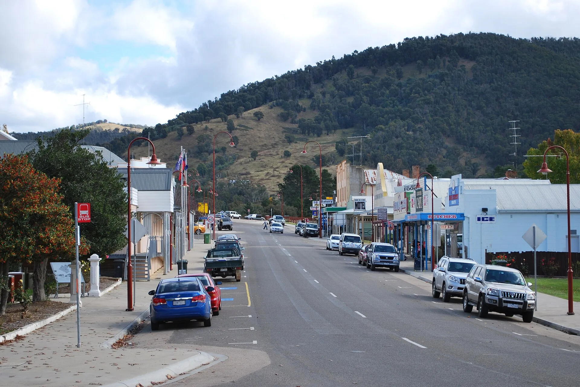 Cars parked along Day Avenue, the main street of Omeo in Victoria's High Country, with hills behind