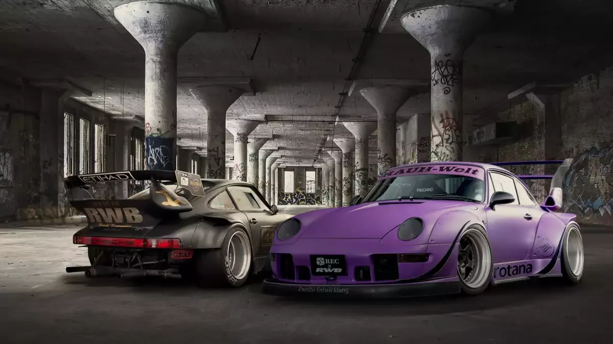 Rear of the matte black RWB 930 Stella Artois showing its RWB mesh wing, parked beside a purple RWB 993