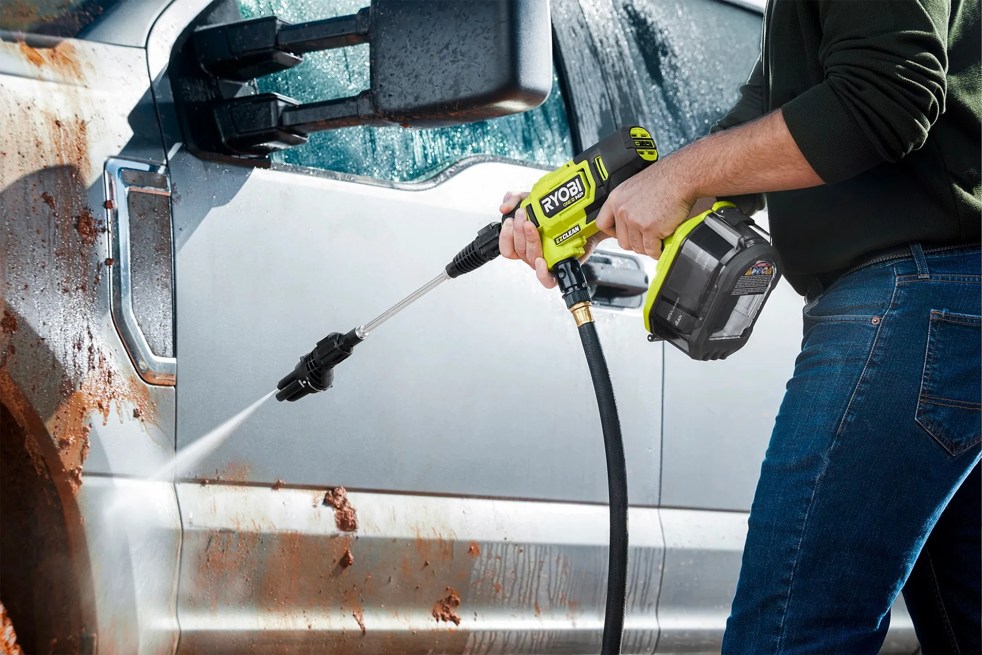 Ryobi 18V ONE+ HP R18XPWS10 cordless power washer rinsing grime off the side of a white van