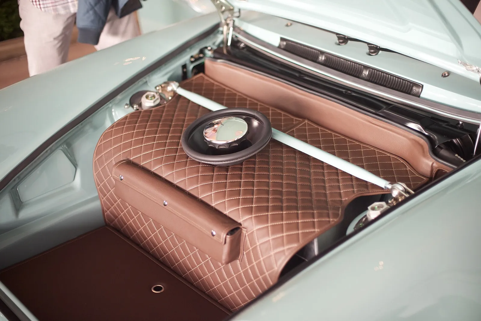 Quilted brown leather lining in the front luggage compartment of a Singer 911, with the fuel cap set through the leather