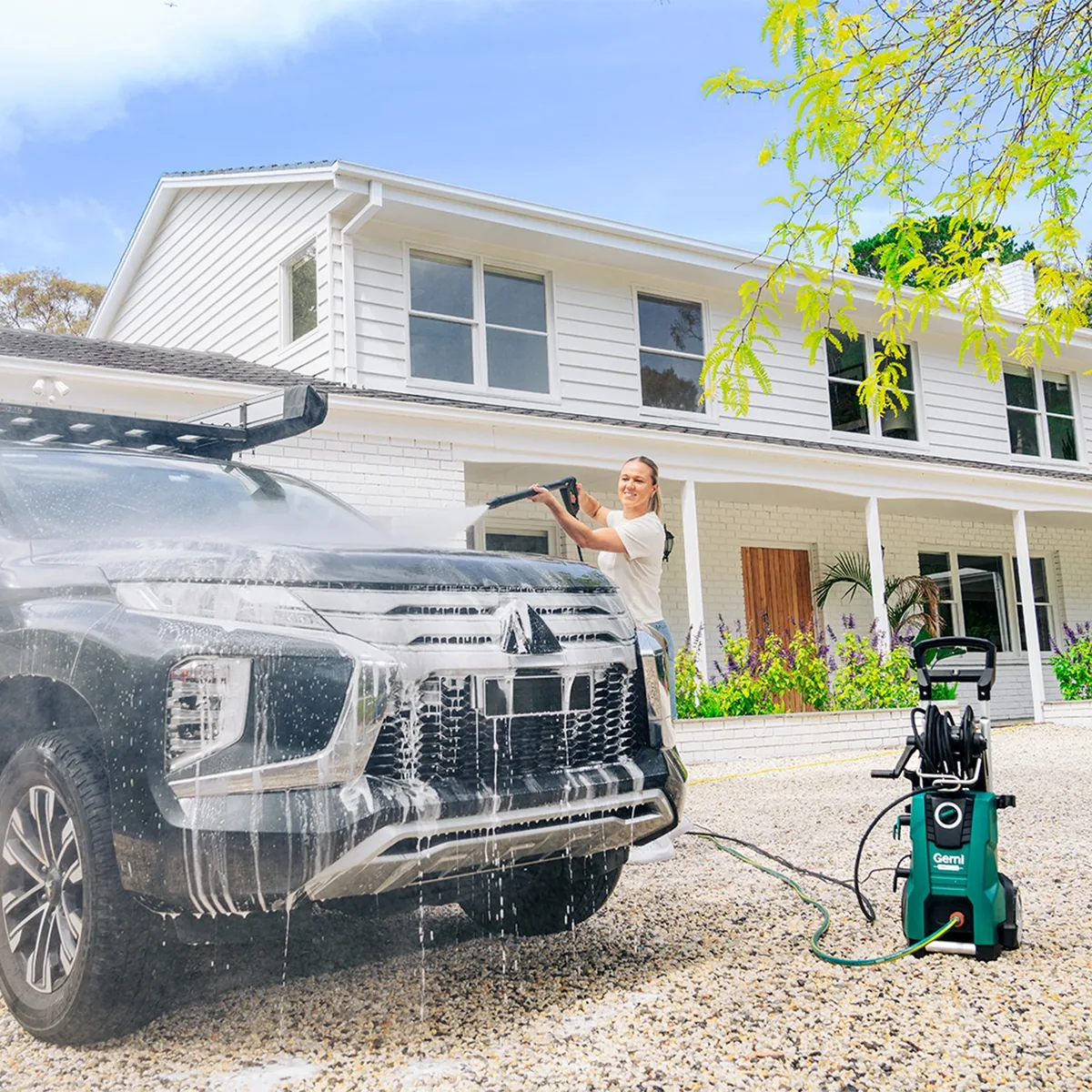 Mitsubishi Triton ute covered in thick snow foam on a driveway beside a Gerni pressure washer