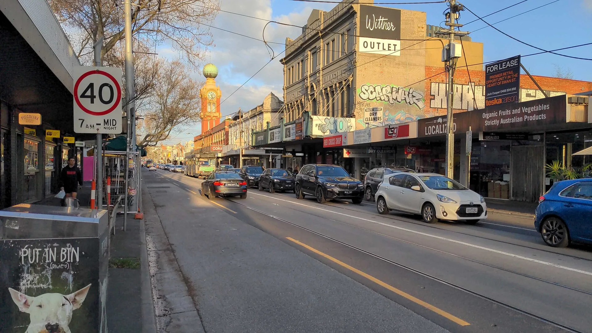 Cars and a tram queued in stop-start traffic under a 40km/h sign on Swan Street in Richmond, Melbourne