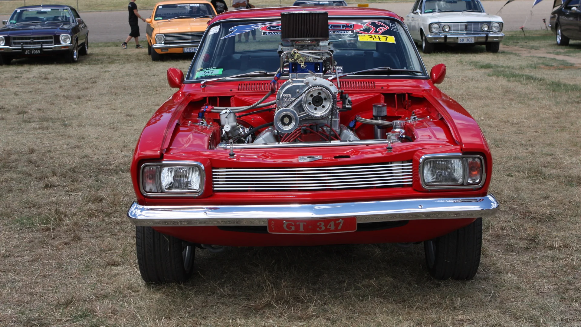 Supercharged street machine at Summernats Red street machine with a supercharger and injector hat poking through the bonnet on the Summernats show field in Canberra