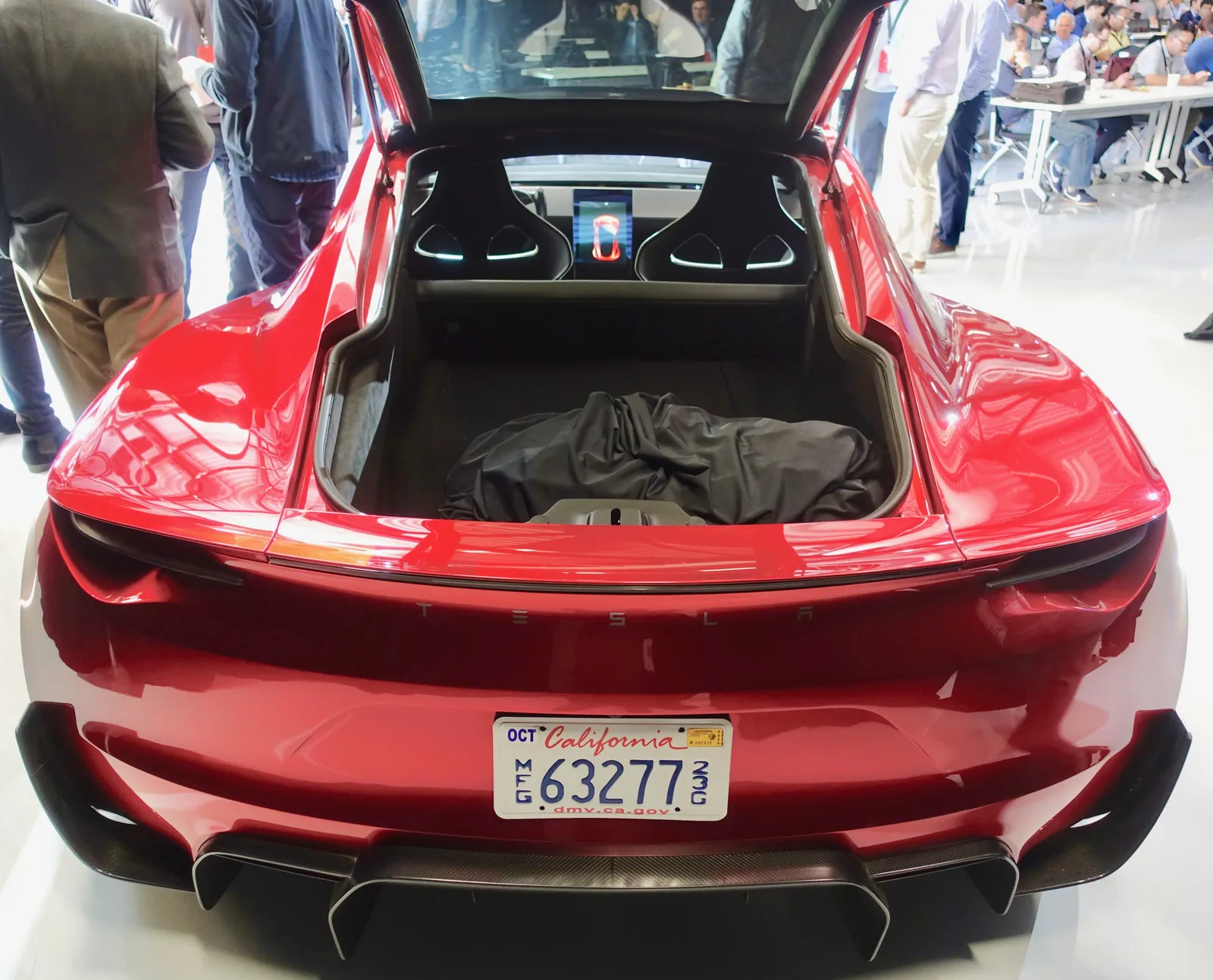 Rear view of the red 2017 Tesla Roadster prototype with its tailgate open, showing the promised 2+2 cabin