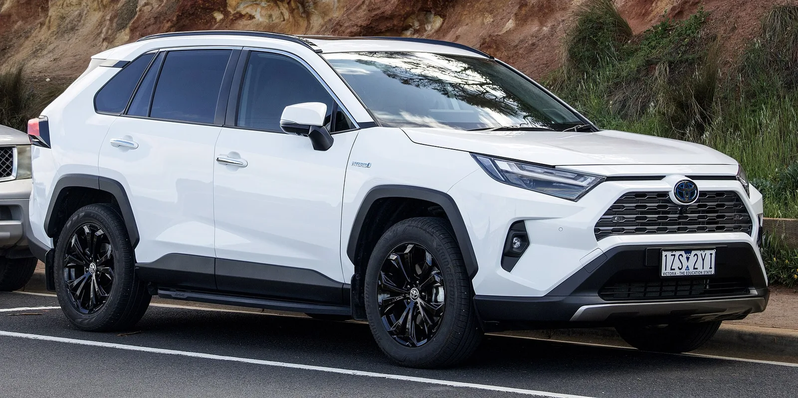 White Toyota RAV4 Hybrid on Victorian plates, a common Australian SUV with a windscreen-mounted safety camera