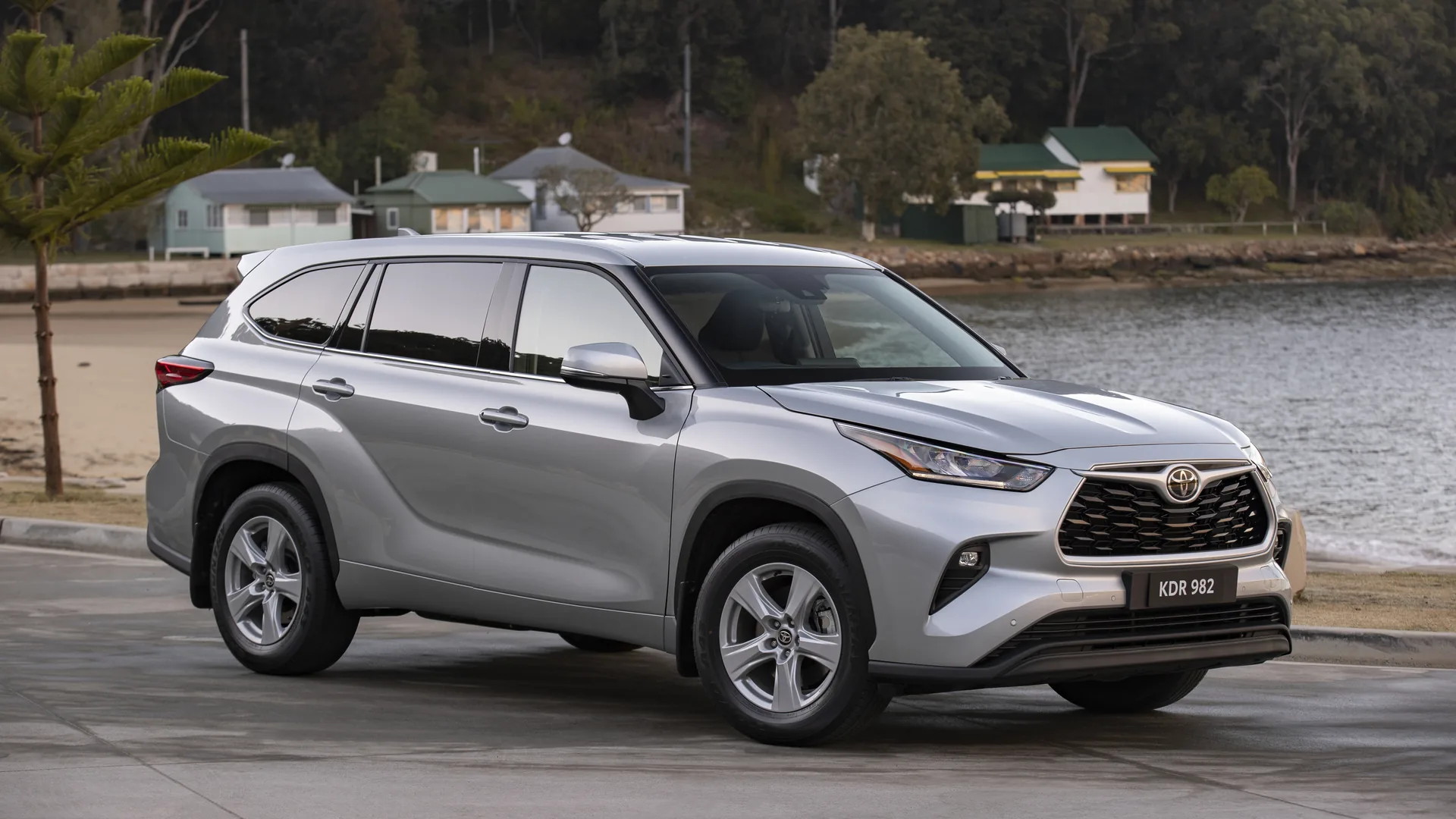 Toyota Kluger with factory rear privacy glass Silver Toyota Kluger GX parked by the water, with lighter front door glass and darker factory privacy glass on the rear doors