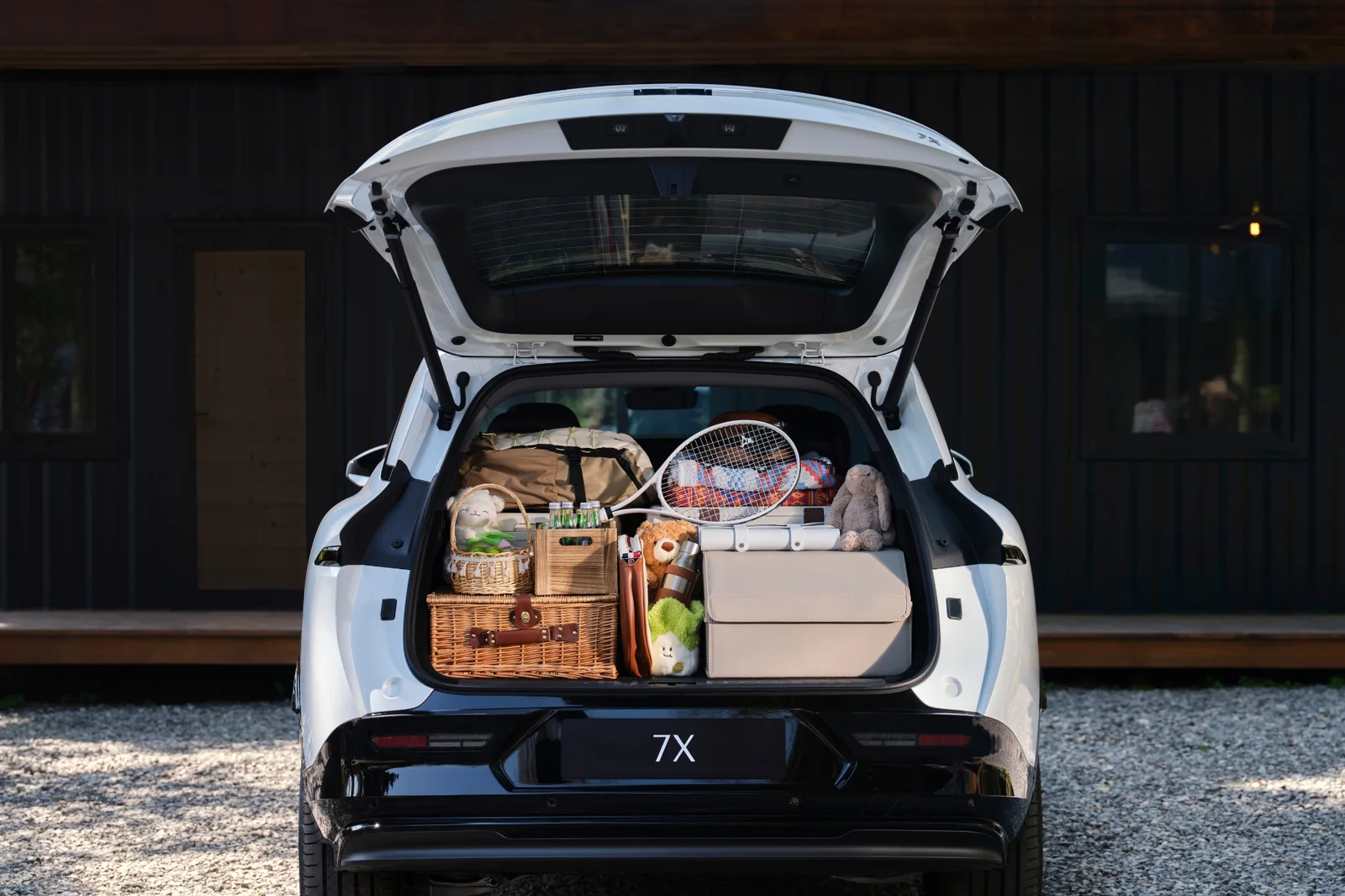 White Zeekr 7X with its tailgate open and the 539-litre boot packed with picnic gear